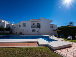 A white building with a swimming pool, a covered patio, and a clear blue sky. - Los Pinos 29 Villas by Casasol by Interhome (Nerja)