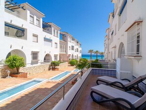 A resort with a pool, lounge chairs, and a view of the sea. - Apartment  by Interhome (Nerja)