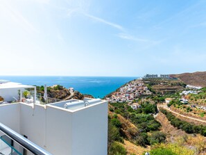 Ein Küstenort mit Häusern, die sich an einen Hügel schmiegen und auf das Meer blicken.