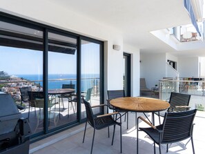 A balcony with a round table and chairs, overlooking a cityscape and the sea. - Balcon del Mar Seaview 211 by Casasol by Interhome (Nerja)
