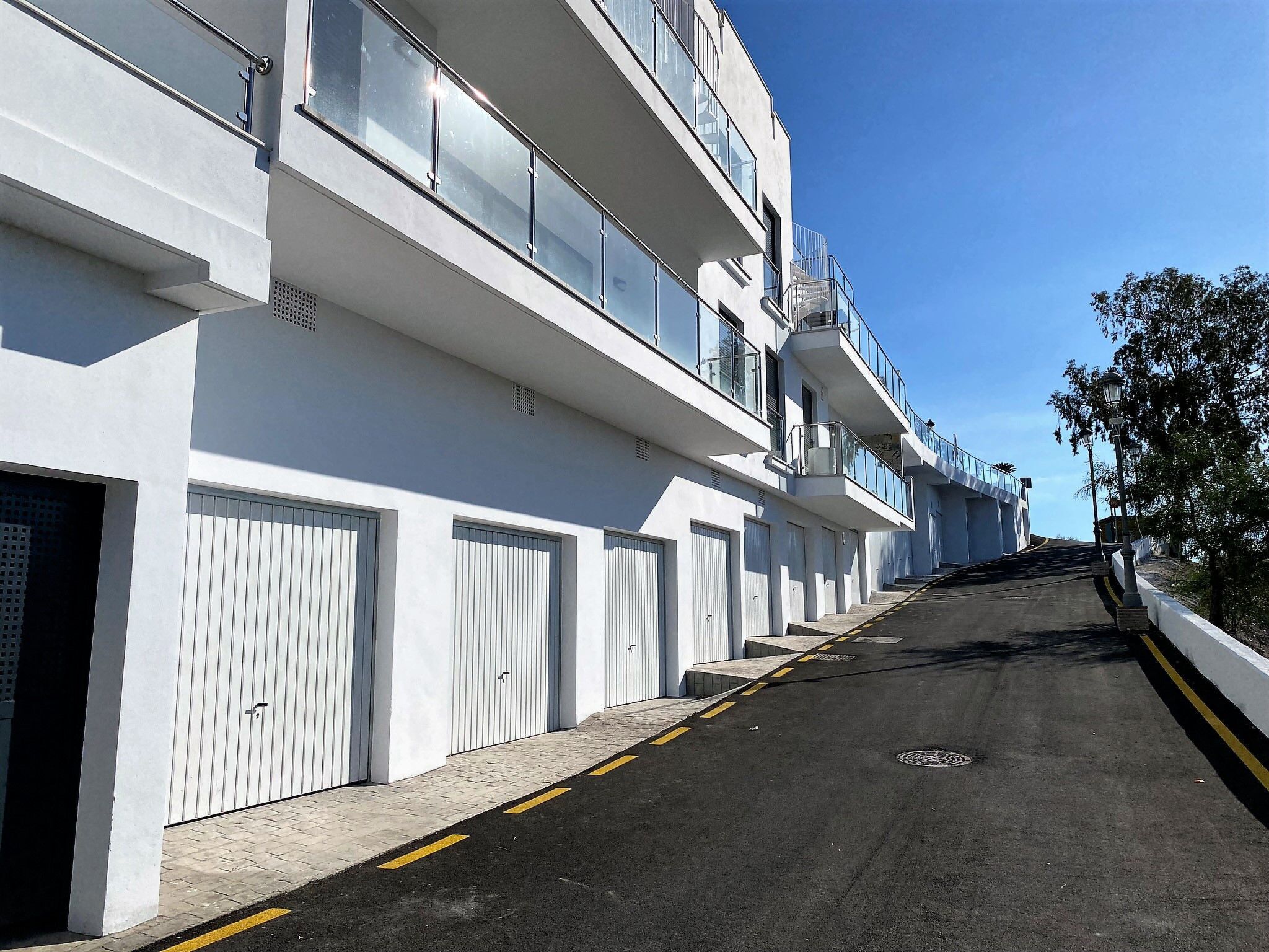 Un immeuble à plusieurs étages, doté de grandes fenêtres et d’une façade sobre, avec un ciel dégagé en arrière-plan.