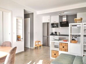 A modern kitchen with white cabinetry, a stainless steel refrigerator, and a microwave. - Apartment  by Interhome (Nerja)