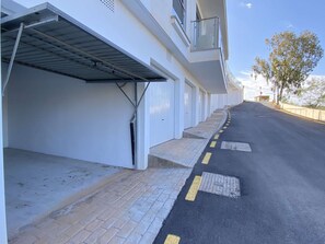 Uma fileira de edifícios brancos com uma galeria coberta que leva à entrada.