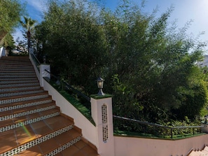 A staircase with patterned tiles leading up to a building, surrounded by lush greenery. - Valparaiso 1B Burriana Beach by Casasol by Interhome (Nerja)