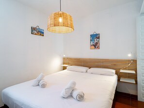 A hotel room with a bed, a bedside table, a lamp, and two wall art pieces. - Arce 5 Torrecilla Beach by Casasol by Interhome (Nerja)