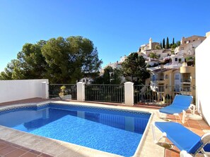 A swimming pool with a tiled edge, surrounded by a low fence and a few lounge chairs. - Villa Lucena Private Pool by Casasol by Interhome (Nerja)