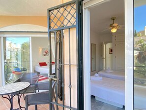 A hotel room with a balcony, a bed, a table with chairs, and a ceiling fan. - Villa Lucena Private Pool by Casasol by Interhome (Nerja)