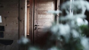 Una porta in legno che dà su una stanza con un interruttore della luce ben visibile e un piccolo ripiano.