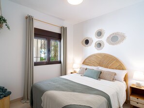 Ein Schlafzimmer mit Bett, Vorhängen, einem Fenster und Wanddekoration.