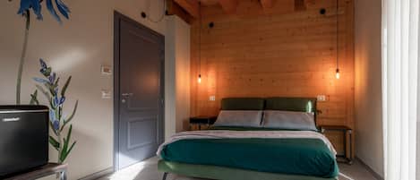 A bedroom with a bed, bedside tables, a television, and a wall-mounted light fixture.