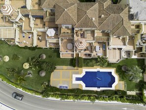 Eine Luftaufnahme eines Wohnhauses mit Pool, mehreren Sitzbereichen im Freien und einem gepflegten Rasen.