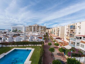 Área residencial com piscina, vários prédios de apartamentos e céu claro.