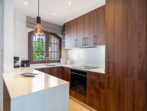 Une cuisine moderne avec des meubles en bois, un îlot central et un lave-vaisselle encastré.
