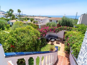 A residential area with a patio, lush greenery, and a view of the sea. - Capistrano Village Casa Corasol by Interhome (Nerja)