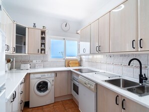 Eine moderne Küche mit Waschmaschine, Backofen und Spüle.