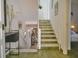 Eine Treppe mit grün gefliesten Stufen, die zu einer Zwischenebene führt.