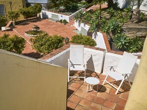 A rooftop terrace with white chairs and a small table, surrounded by a garden with various plants and a bench. - Casablanca 9 Punta Lara by Casasol by Interhome (Nerja)