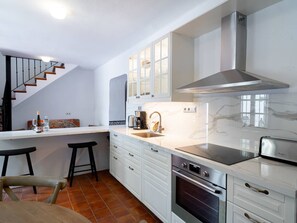 A modern kitchen with white cabinets, a stainless steel range hood, and a built-in oven. - Villa Lorca Vista Mar by Casasol by Interhome (Nerja)