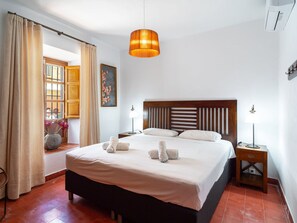 A hotel room with a bed, bedside lamps, a window with curtains, and a painting on the wall. - Villa Lorca Vista Mar by Casasol by Interhome (Nerja)