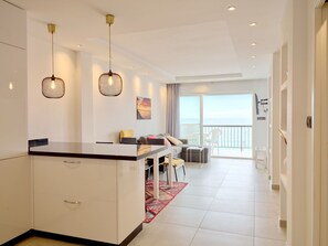 Een moderne hotelkamer met een keukenhoek, eethoek en een balkon met uitzicht.