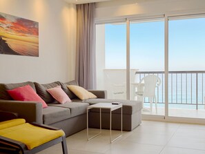 A modern living room with a grey sofa, a small white table, and a yellow chair. - Apartment  by Interhome (Nerja)