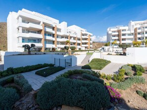 A modern apartment complex with multiple balconies, a landscaped courtyard, and a clear sky. - Luxury Pool View Isea 1111 by Interhome (Torrox Costa)