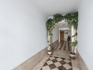 A hallway with a checkered floor, white walls, and a wooden door at the end. - Torrecilla Urban Beach Stay by Interhome (Nerja)