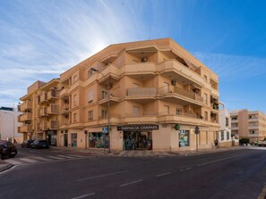 A multi-story building with balconies, a pharmacy on the ground floor, and a clear sky. - Torrecilla Urban Beach Stay by Interhome (Nerja)
