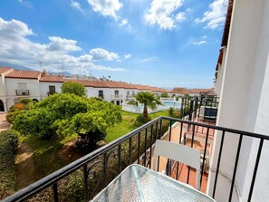 Ein Balkon mit Blick auf eine Wohngegend, einen Swimmingpool und einen klaren Himmel.