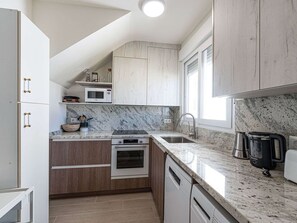 A modern kitchen with a built-in oven, microwave, and stainless steel appliances. - Hacienda 4A by Casasol by Interhome (Nerja)