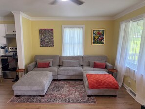 A living room with a sectional sofa, a patterned rug, and artwork on the walls. - Lovely house in High Point perfect for your next getaway, located next to HPU! (High Point)