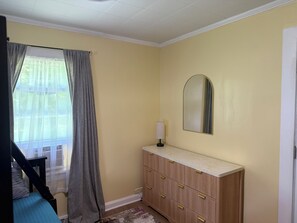 A room with a bed, a dresser, a mirror, and a window with curtains. - Lovely house in High Point perfect for your next getaway, located next to HPU! (High Point)