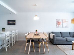 A modern living space with a dining area, a grey sofa, and artwork on the walls. - Duna Beach Torrox Costa by Casasol by Interhome (Torrox Costa)
