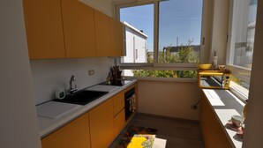 A compact kitchen with a window, a sink, and a small countertop. - Romeo House (Cagliari)
