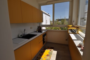 A compact kitchen with a window, a sink, and a small countertop. - Romeo House (Cagliari)