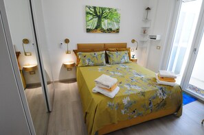 Une chambre à coucher avec un lit, des oreillers, une table de chevet, une lampe et un tableau au mur.