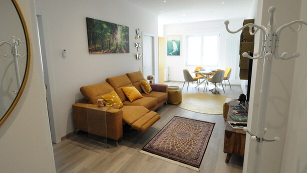 A modern living room with a sofa, a coffee table, and a dining area with chairs. - Romeo House (Cagliari)