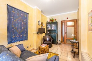 A living room with a sofa, a coffee table, a rug, a cabinet with glass doors, and a door with a mirror. - Gaudio Flat near Ariston Theater by Wonderful Italy (Sanremo)
