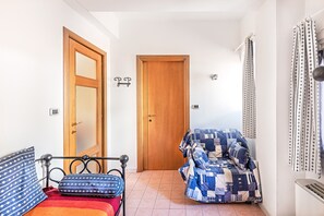 A bedroom with a bed, a wooden door, a window with curtains, and a radiator. - Gaudio Flat near Ariston Theater by Wonderful Italy (Sanremo)