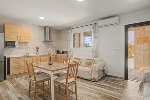 Eine moderne Küche mit Holzausbau, einem Esstisch mit Stühlen und einem Sofa.
