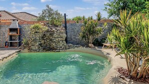 A swimming pool with a stone wall and a barbecue grill. - Holiday Home 'El Islote del Sur' with Private Pool, Wi-Fi & Air Conditioning (Conil de la Frontera)