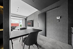Un interior moderno con una mesa de conferencias, sillas, un televisor montado y un termostato en la pared.