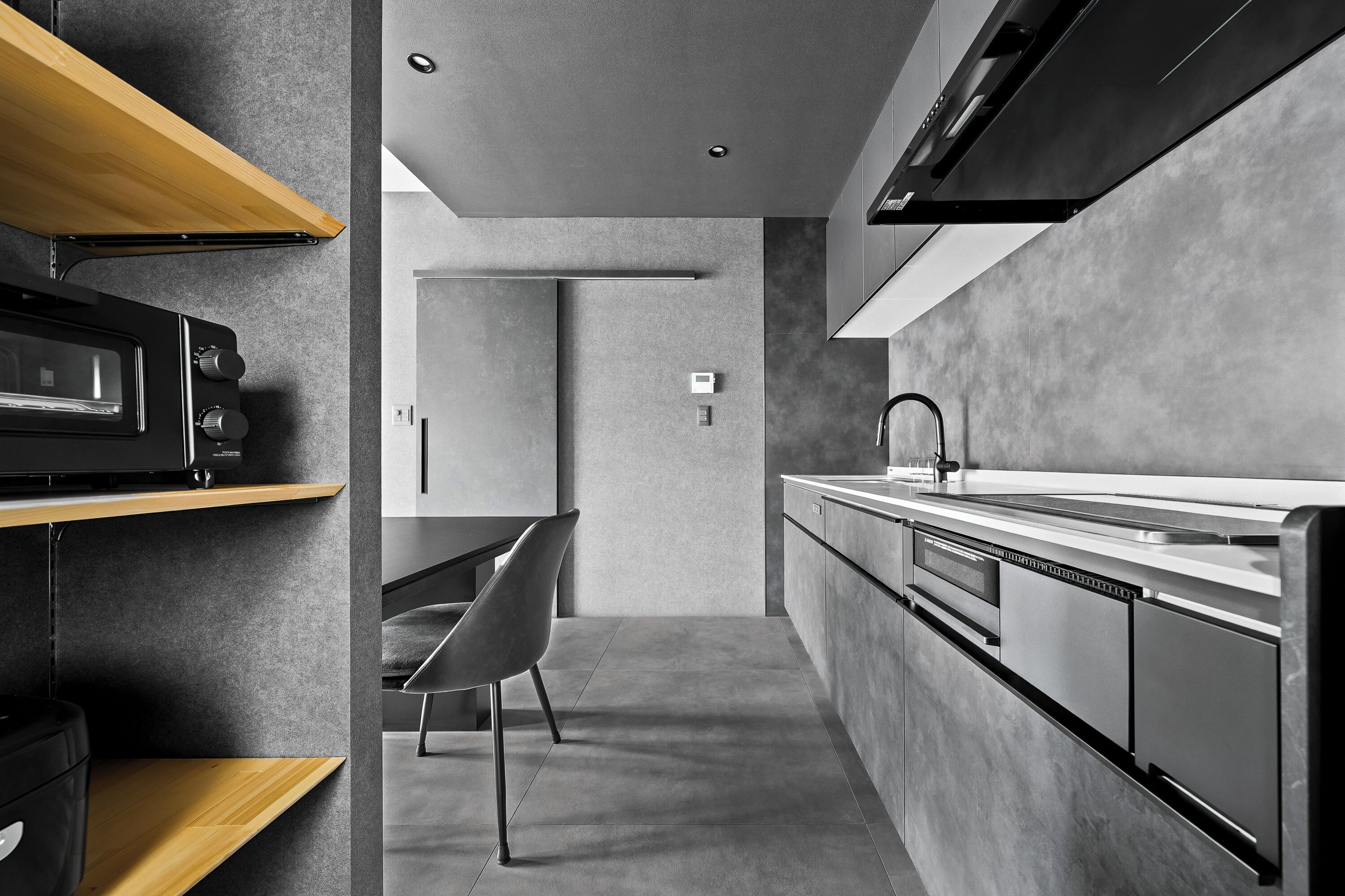 A modern kitchen with a built-in oven, microwave, and a sleek faucet.