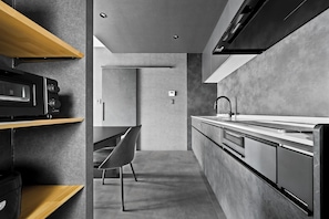 A modern kitchen with a built-in oven, microwave, and a sleek faucet. - HT-I (Asahikawa)