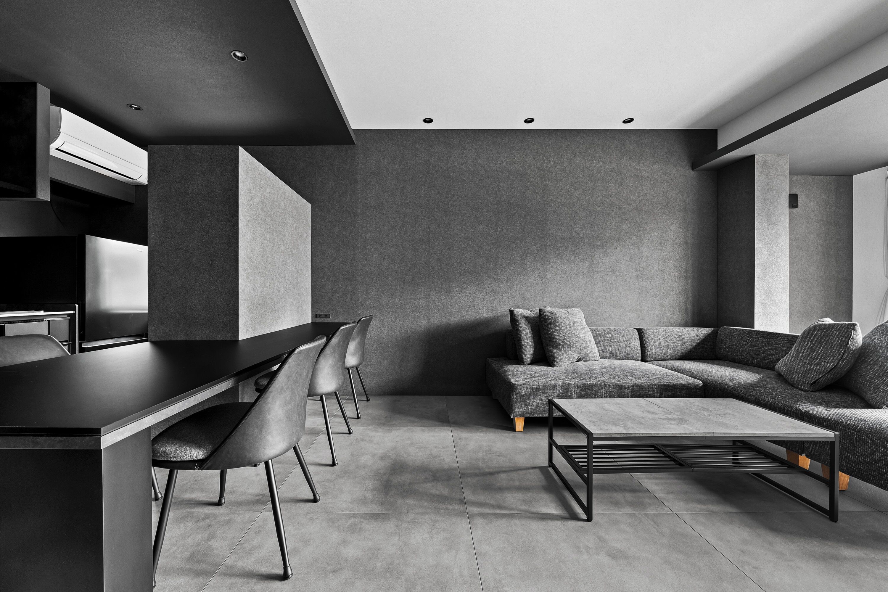 Un interior moderno con zona de comedor, sofá y mesa de centro.
