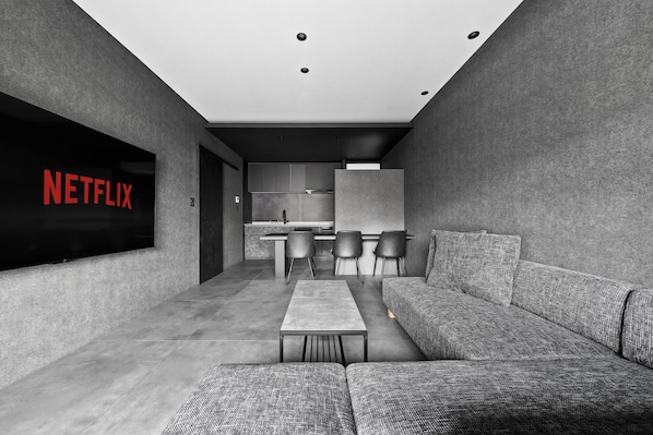 Una sala de estar moderna con un sofá modular, un televisor de pantalla plana y un diseño minimalista.