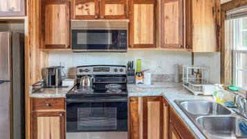 A kitchen with wooden cabinets, stainless steel appliances, and a window providing natural light.