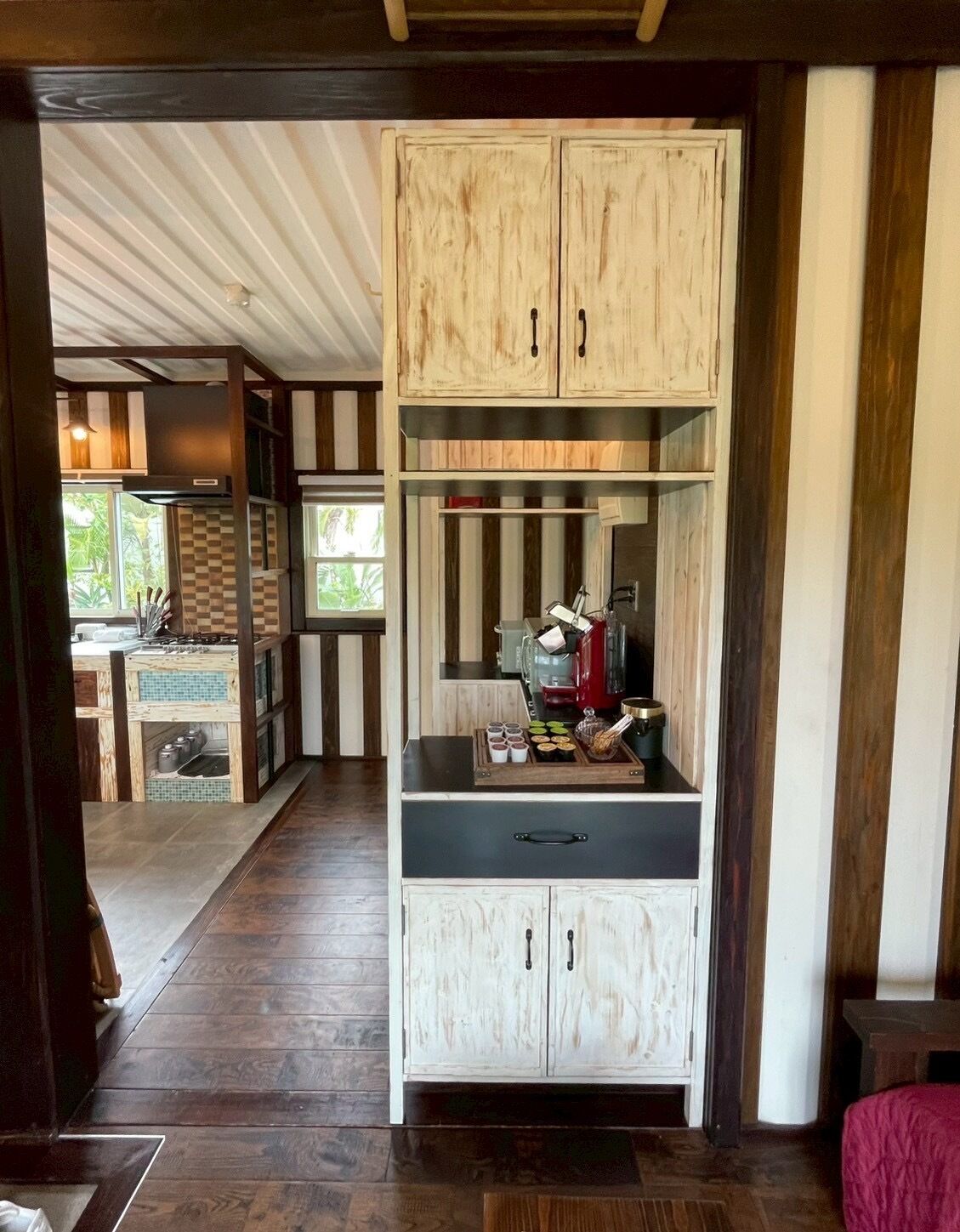 Une cuisine avec des meubles en bois, un plan de travail et une vue sur l’extérieur.
