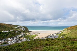 Eine Küstenstadt mit Strand, Häusern und einer Straße, die zum Meer führt.