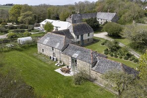 A stone house with a sloped roof, surrounded by a well-maintained lawn and a variety of trees. - Avallen Barn - sleeps 8 guests  in 4 bedrooms (Helford)